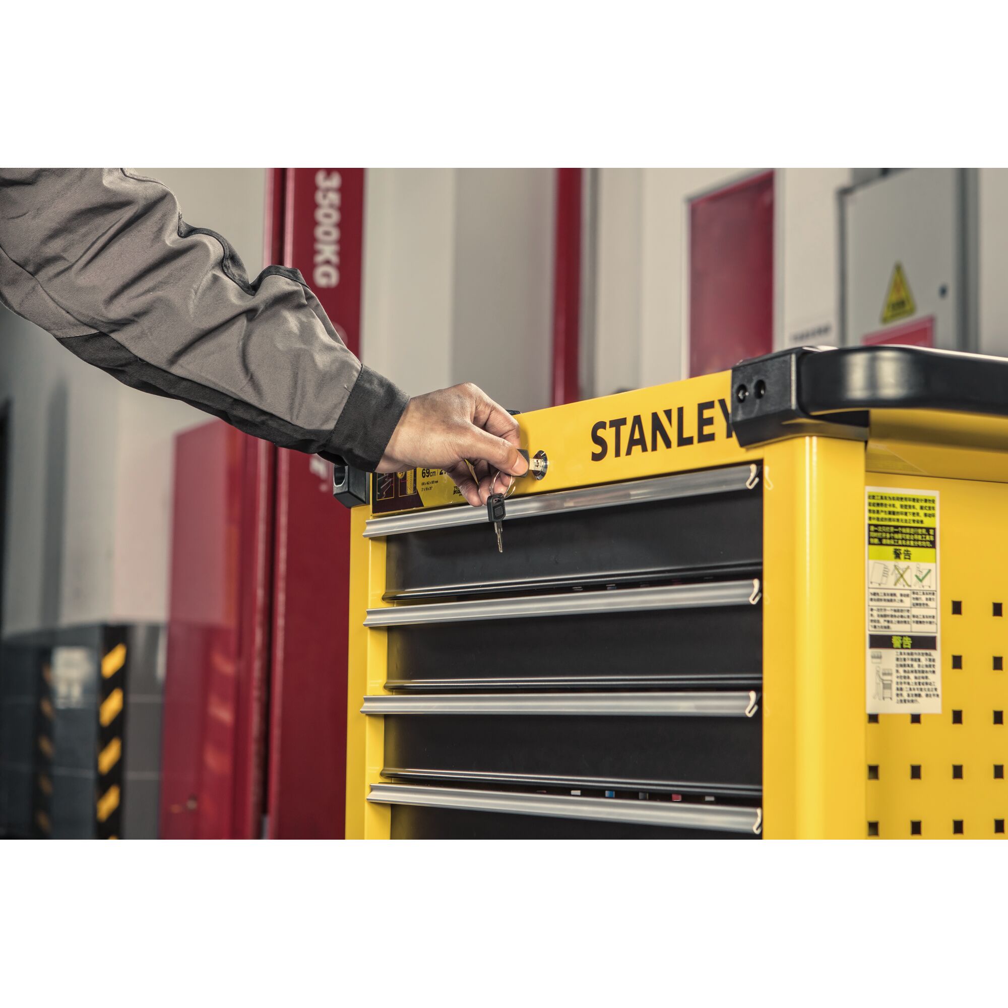 Man locking 7 drawers metal roller cabinet with a set of keys