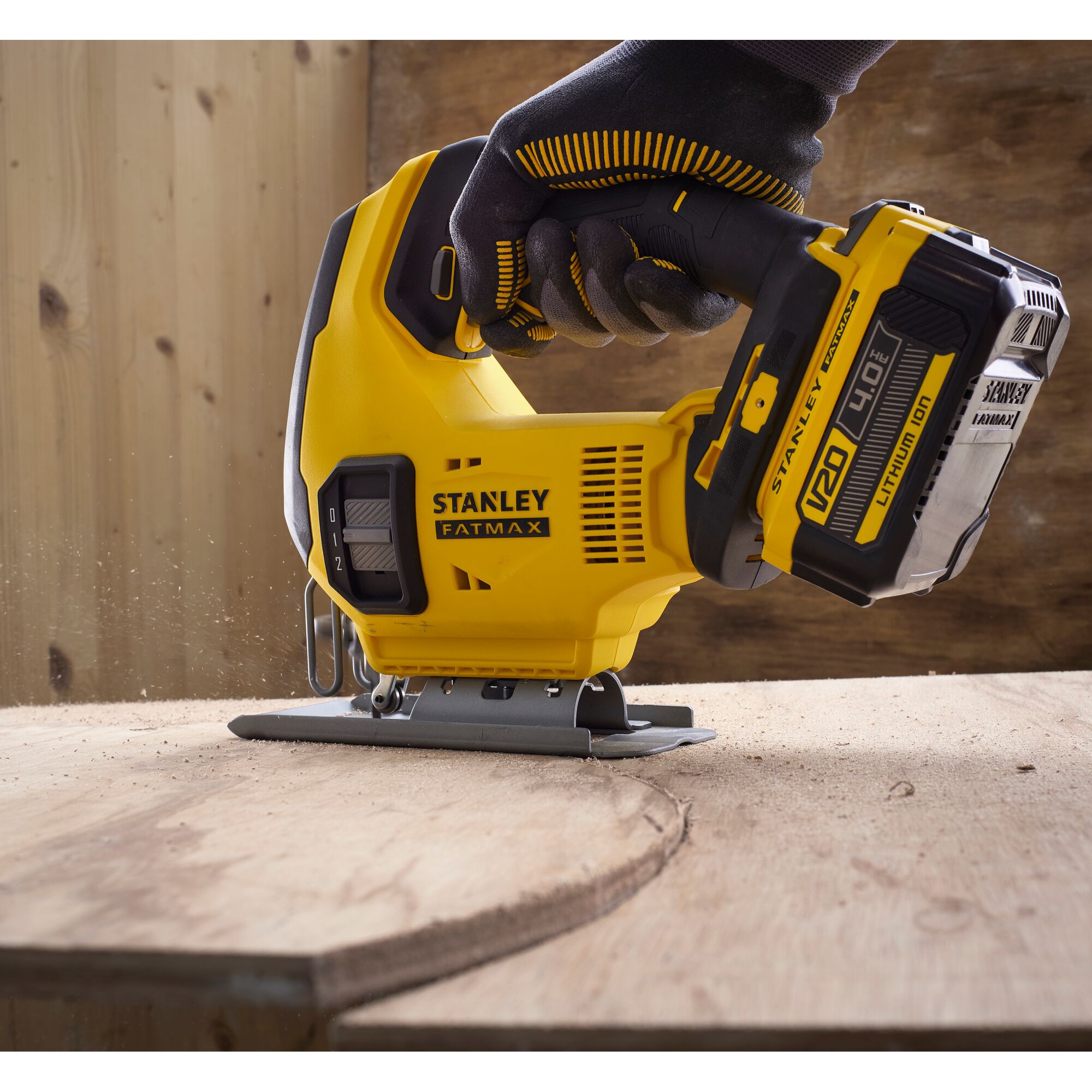 Photo of STANLEY SCJ600 jigsaw cutting wood, yellow and black design, handheld in woodworking setting.