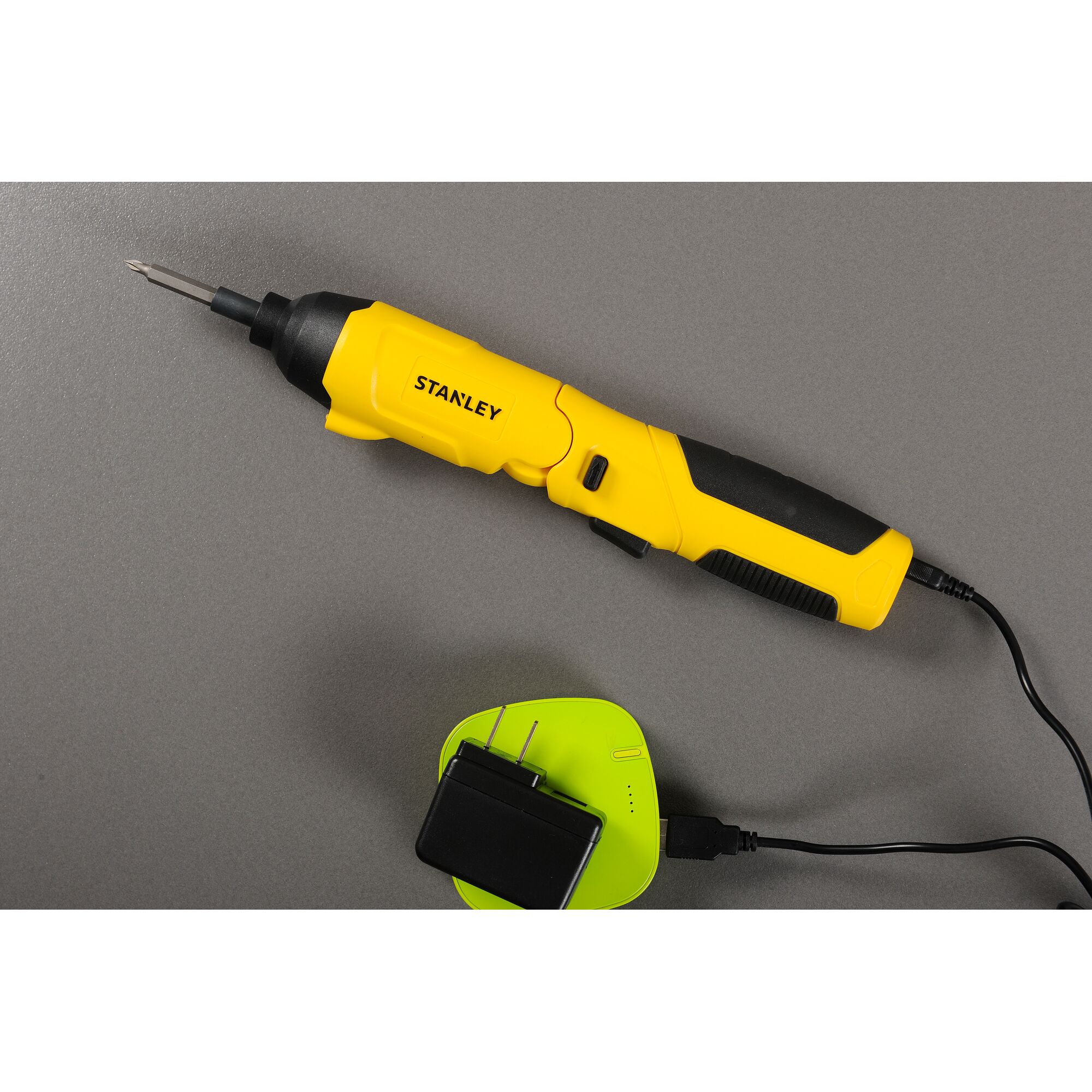 Stanley SCS4K yellow electric screwdriver with black grip and charger, top view photography