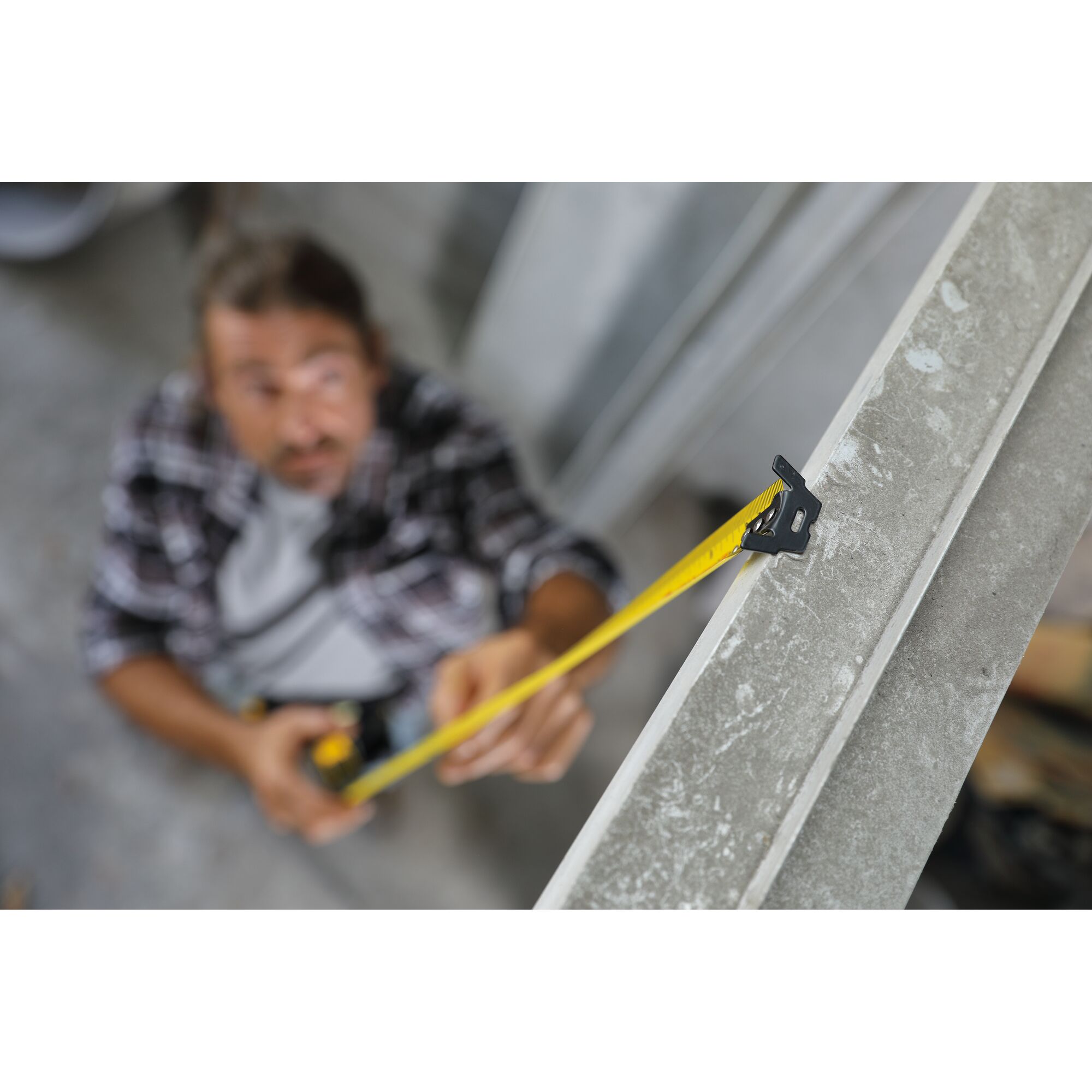 STANLEY STHT36195 tape measure in use, measuring a metal beam, close-up photography.