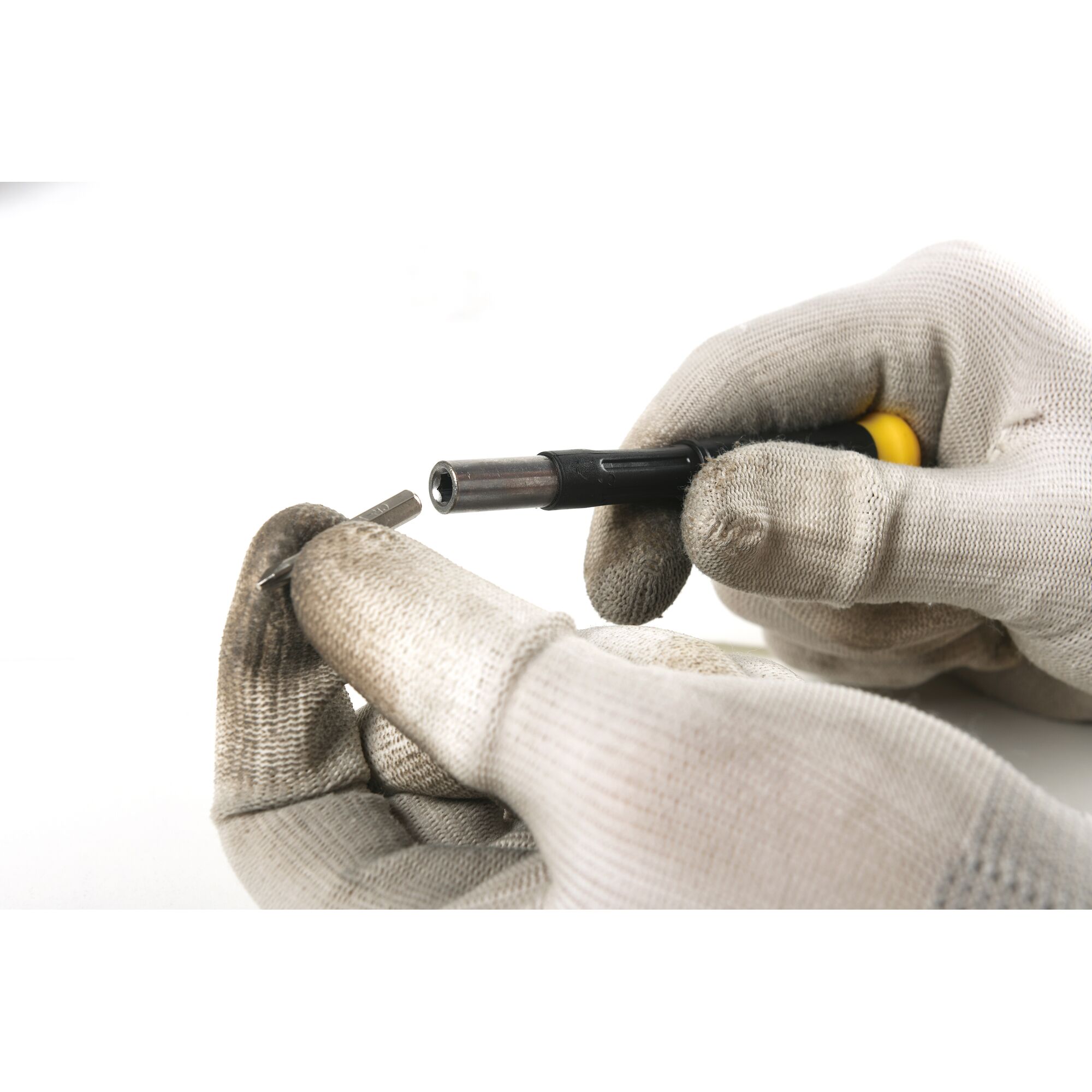 STANLEY STHT68010-8 screwdriver set, close-up photo of gloved hands changing screwdriver bit.