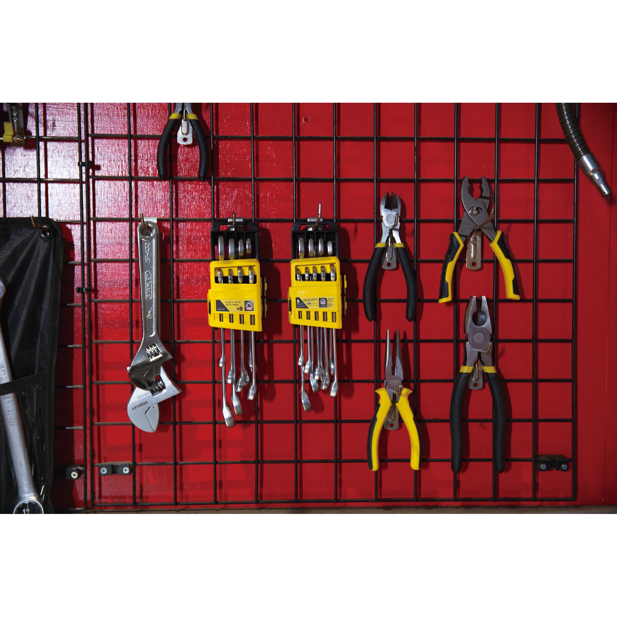 STANLEY STMT78099-8 hand tools set with yellow racks on red grid wall, front angle