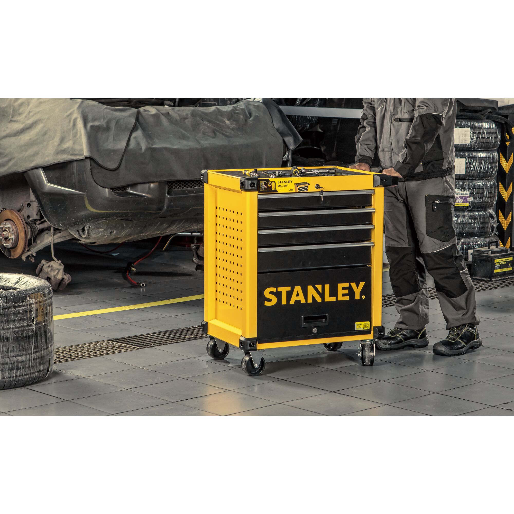 STANLEY STST74305-8 yellow and black rolling tool cabinet with drawers in a workshop setting.