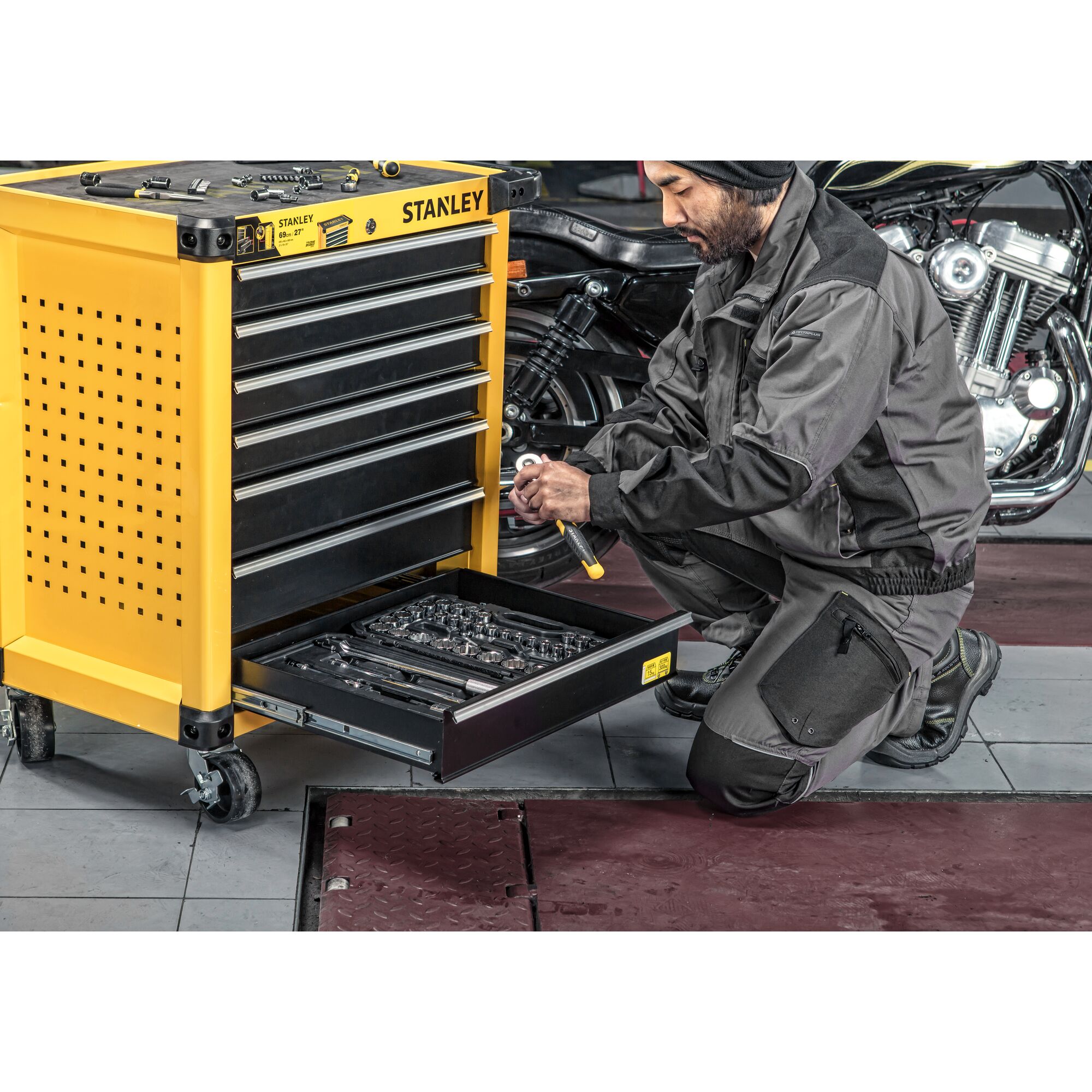 Stanley STST74306-8 yellow tool chest with open drawer of wrenches in garage workshop, side angle.
