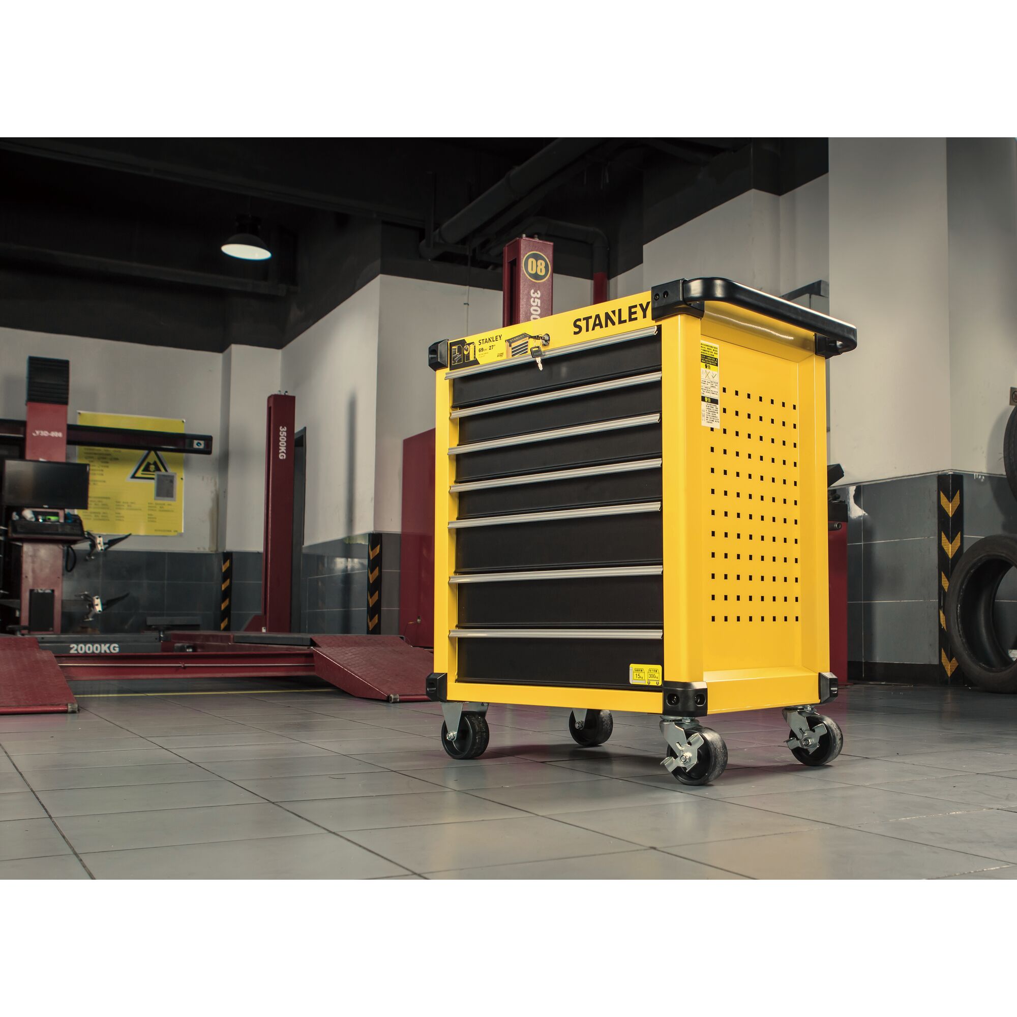 STANLEY STST74306-8 yellow tool cabinet with five drawers on wheels in garage setting.